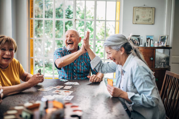 personnes âgées jouant des cartes dans la maison de soins infirmiers - personne agée jeu photos et images de collection